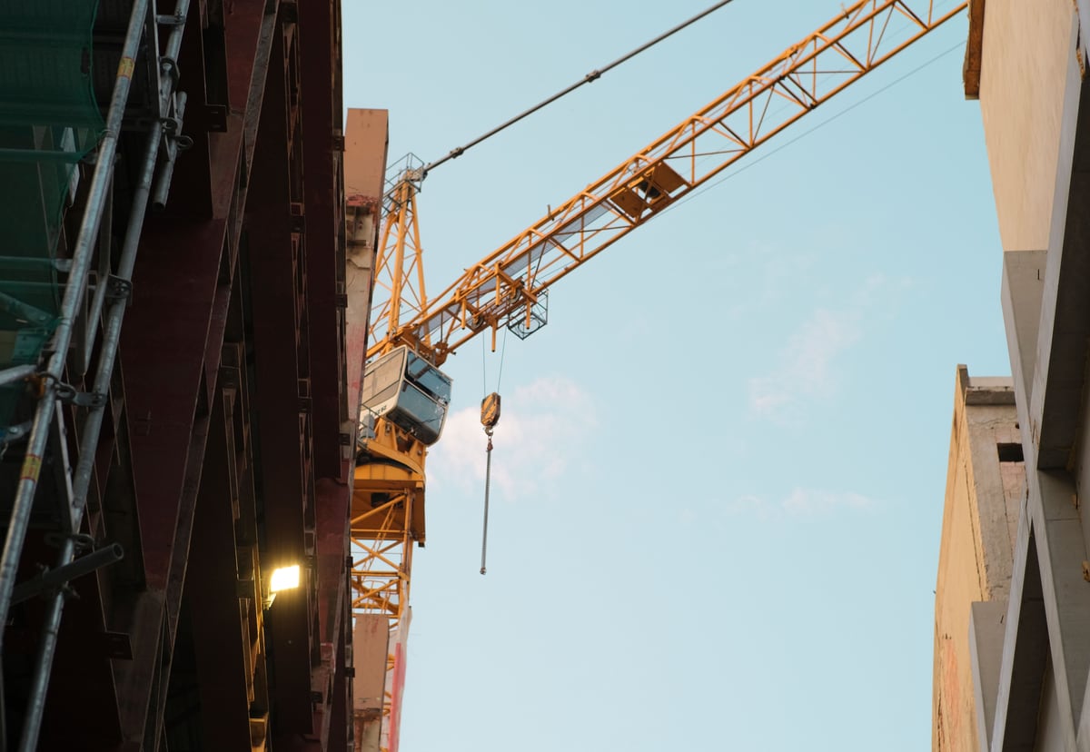 Construction crane between buildings representing build versus buy technology decisions