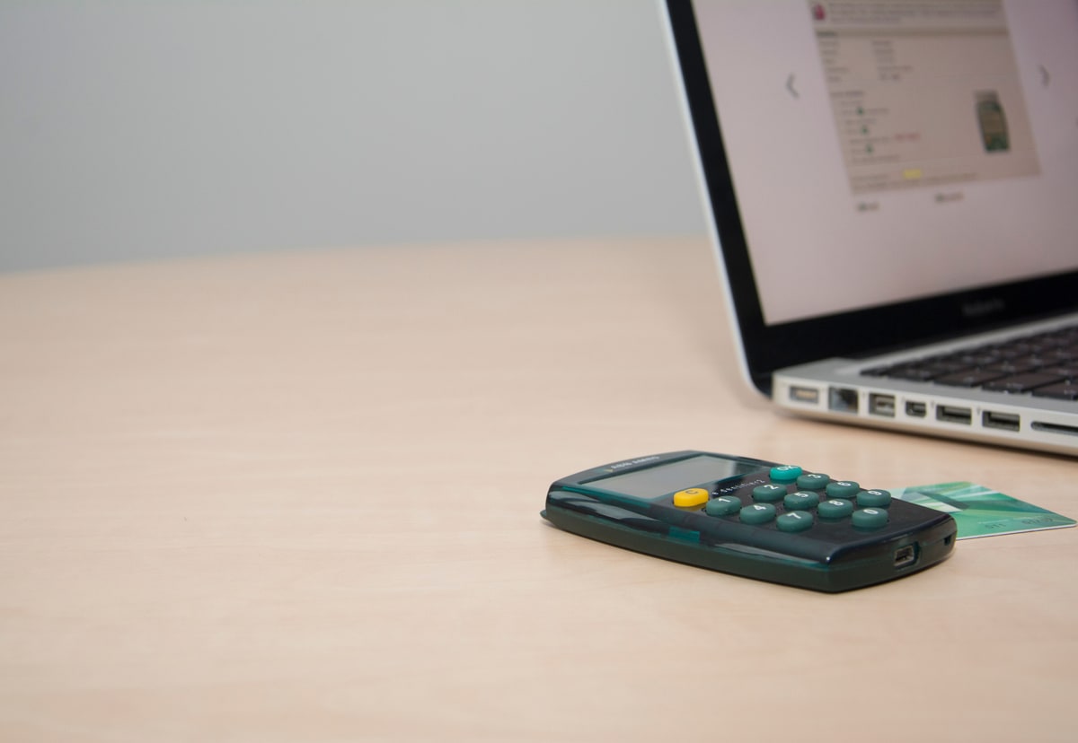 Calculator, payment card and laptop on a desk, representing SaaS churn calculations and subscription billing