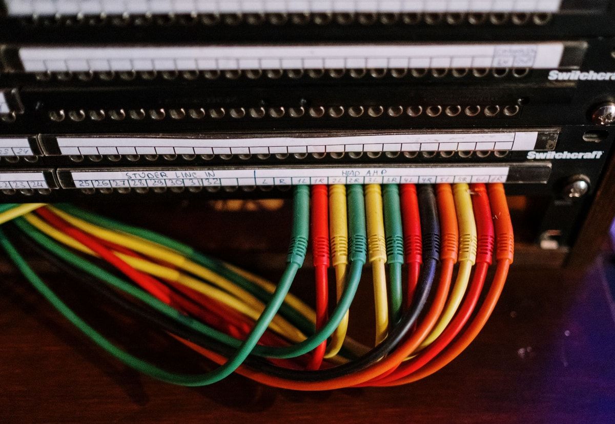 Colourful labelled cables connected to a patch panel, representing MCP connections between AI and business systems